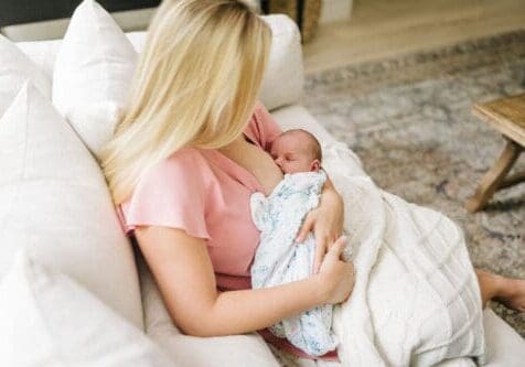 New mom in Tampa FL breastfeeding on couch at home