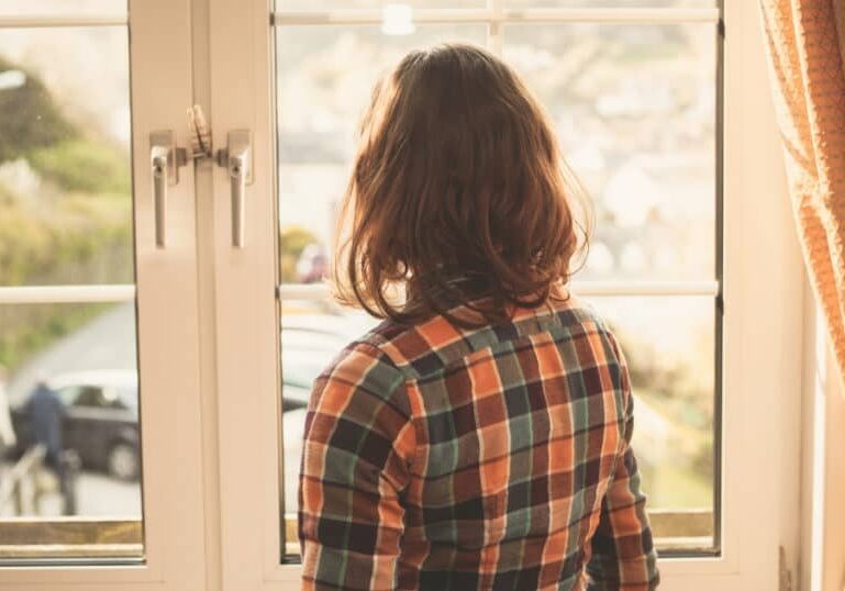 new mom looking out window postpartum