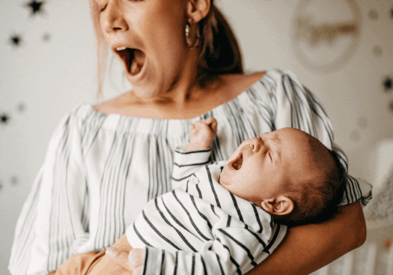 new mom and baby yawning together in nursery