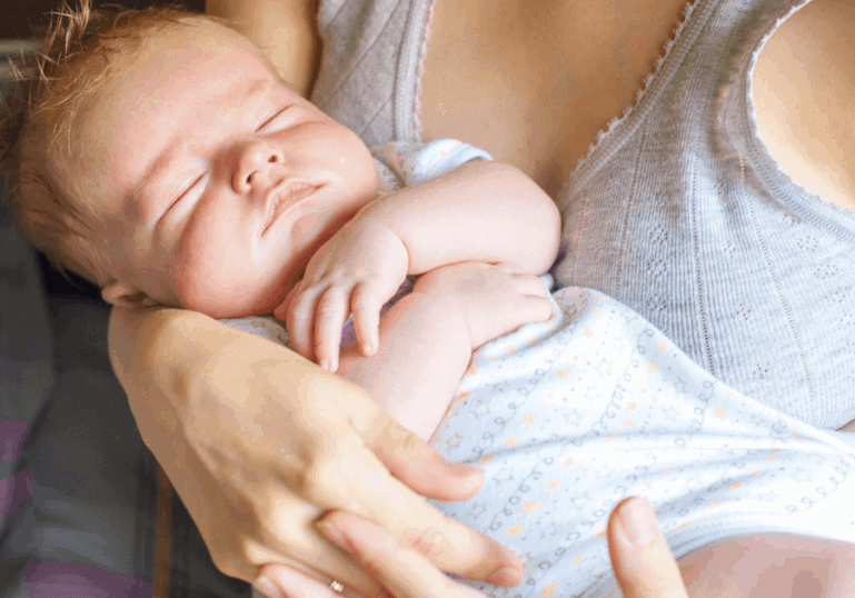 sleepy baby held by mother
