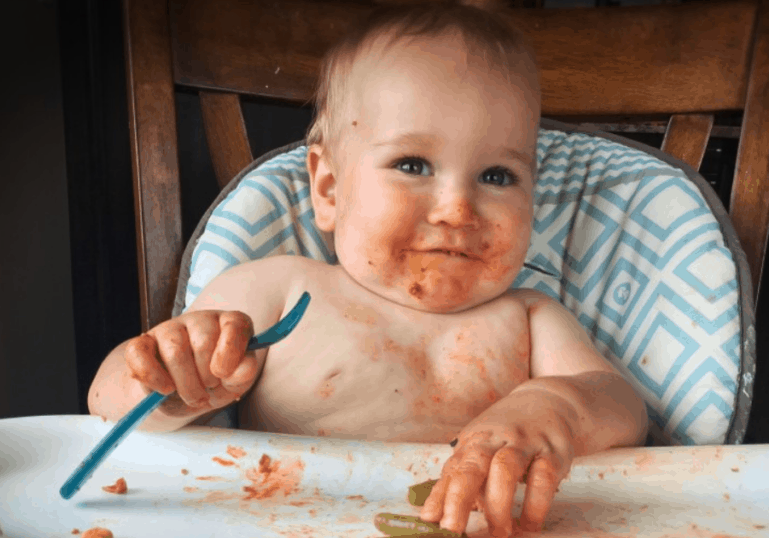 older baby with messy face after eating solid foods