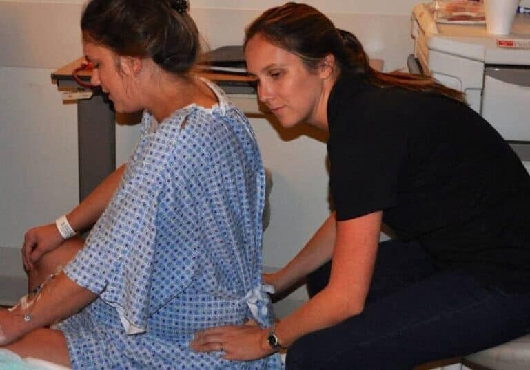 Buddha Belly Doula providing back massage at hospital birth in Tampa, FL
